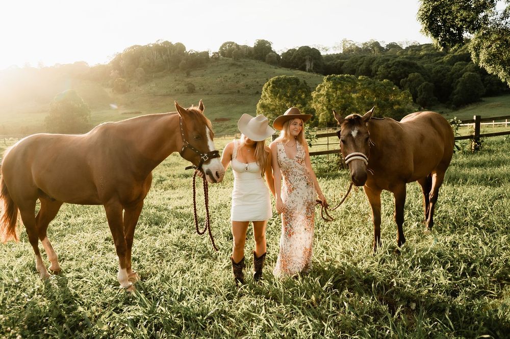 Two women with horses at sunset