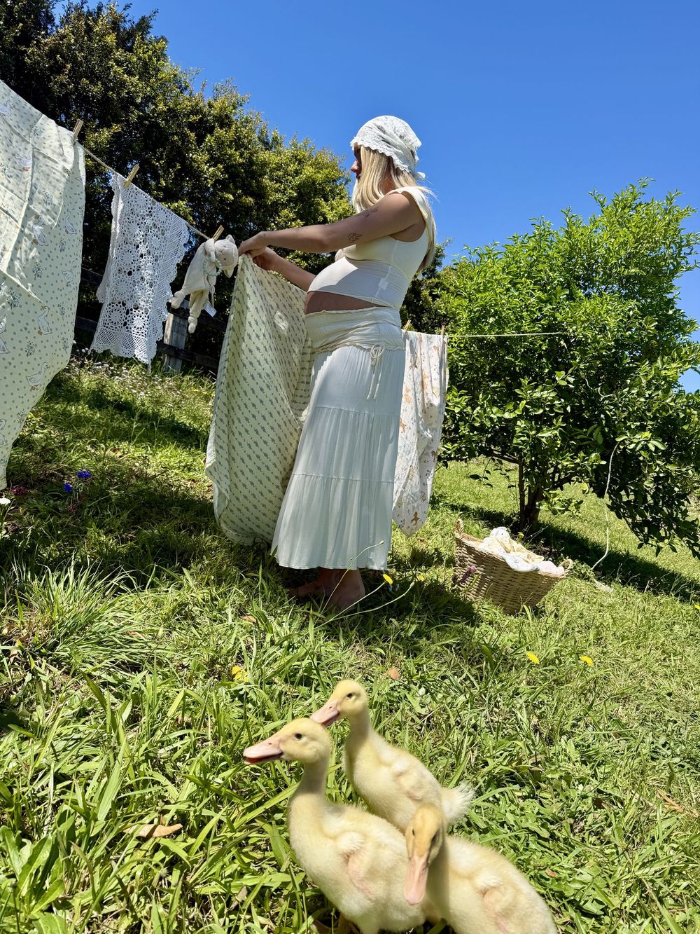 Maternity portrait with ducklings by the washing line
