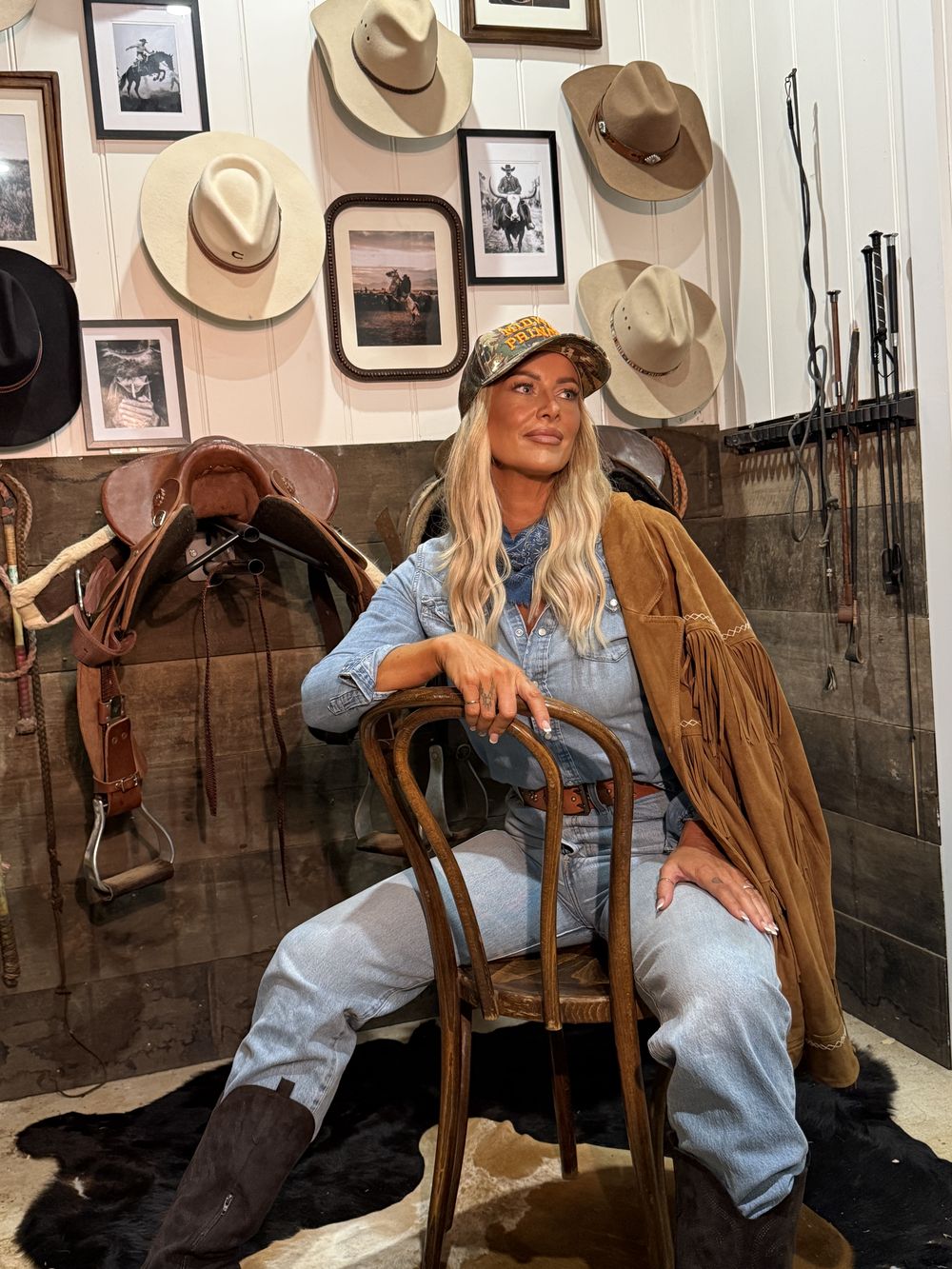 Model seated on a chair in the tack room